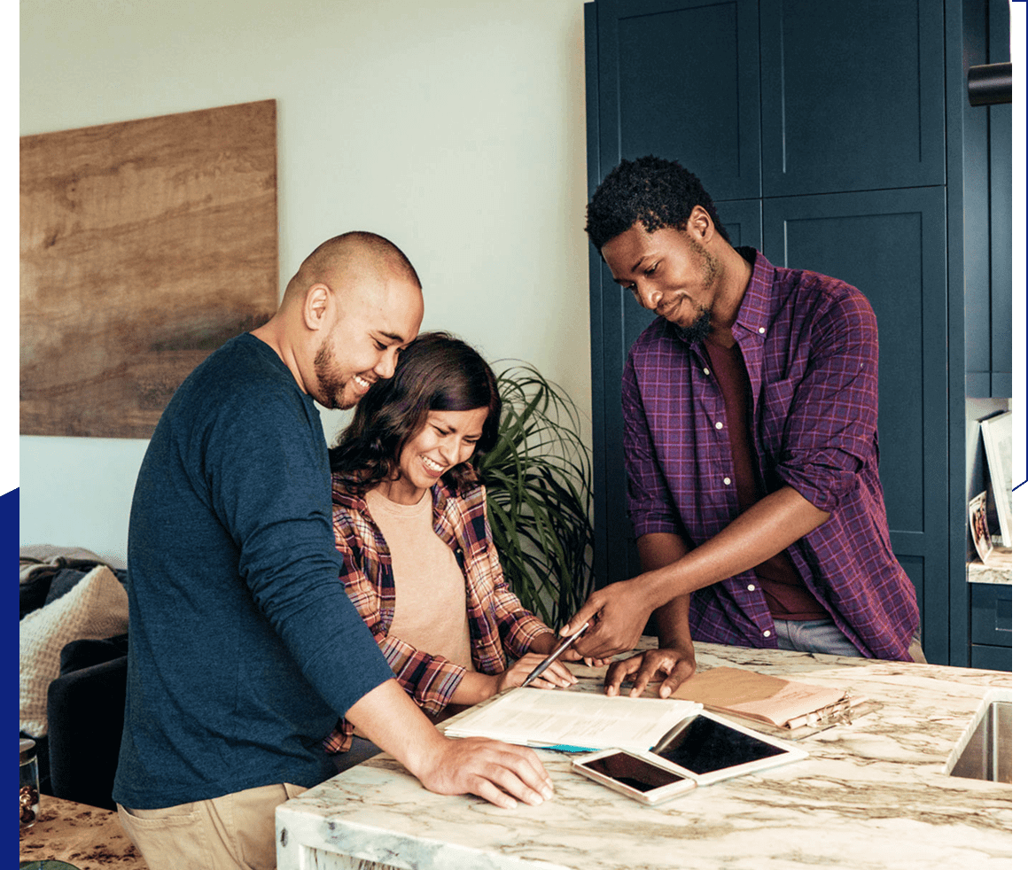 Three people collaborating at a kitchen counter.